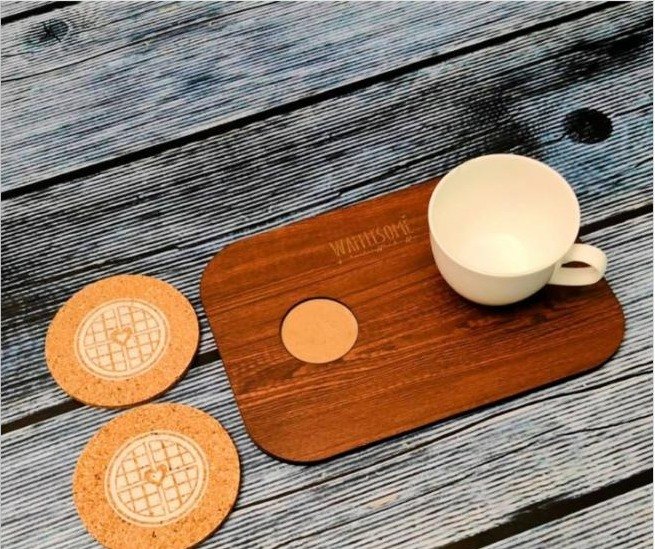 Custom branded cork coasters and a wooden MDF serving tray with a cup, styled on a table