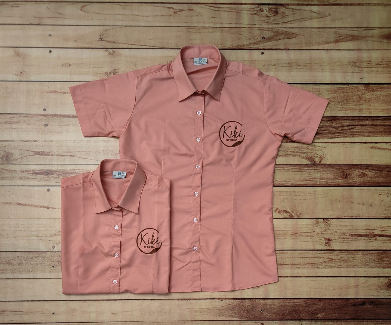 Stack of custom restaurant uniform shirts ready for dispatch, made by RestroCart, New Delhi